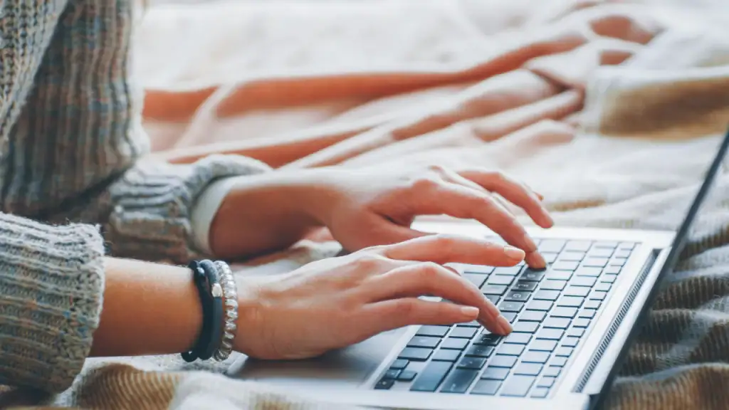Laptop hands typing on a keyboard for social media content creation and digital marketing.